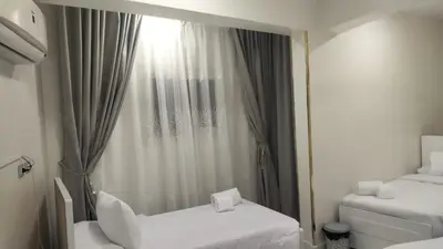 a room with two beds and a window at Aswan Key Cozy in Nag` el-Ramla