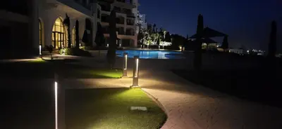 an empty street at night with lights on the grass at Susi`s TheView Luxuriöse Ferienwohnung mit fantastischem Meerblick in Hurghada