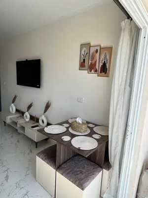 a living room with a table and a tv at Benashti Hurghada apartment 407 in Hurghada