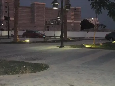 an empty street at night with cars parked in a parking lot at ALDAU Heights Mountain View in Hurghada