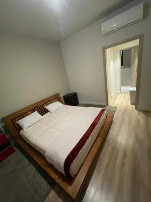 a bedroom with a large bed with a wooden frame at ElGouna, Elegant 1Bedroom, private patio in Fanadir Marina in Hurghada