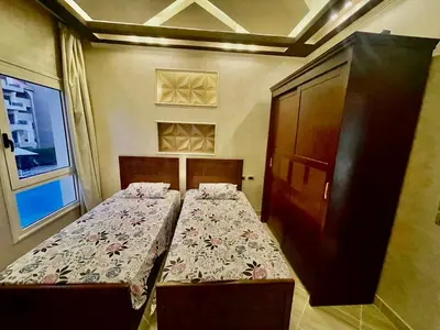 a bedroom with two beds and a cabinet at Sahl Hasheesh, El Andalous by sea and pool view, private beach in Hurghada