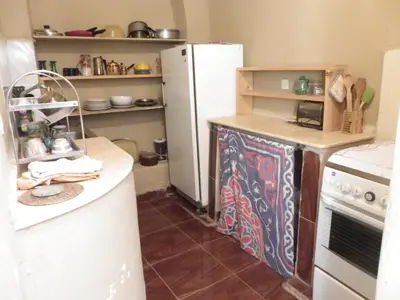a kitchen with a white refrigerator and a stove at maison luxor in Al Aqālitah