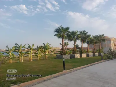 a park with palm trees in front of a building at Selena bay resort in Hurghada