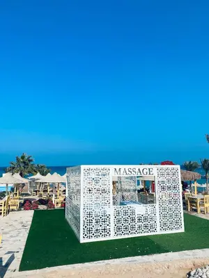 a sign on the grass next to the beach at Apartment in el karma aqua beach resort hurghada near el gouna 2 in Hurghada