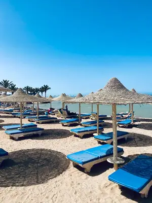 a group of beach chairs and umbrellas on a beach at Apartment in el karma aqua beach resort hurghada near el gouna 2 in Hurghada