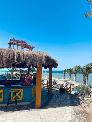 a bar on the beach with a straw roof at Apartment in el karma aqua beach resort hurghada near el gouna 2 in Hurghada