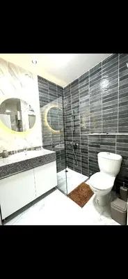 a bathroom with a toilet and a sink and a mirror at Tolles Modernes Studio in Selena Bay in Hurghada
