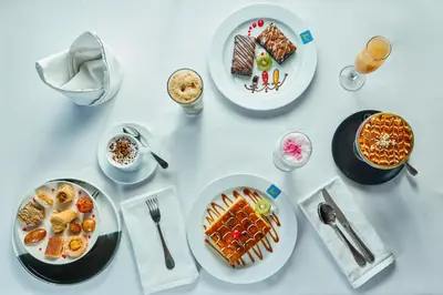 a white table with plates of food on it at Al Fanar Azur Hotel in Suwhaj