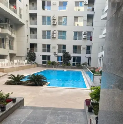 a swimming pool in front of a large building at Red sea-Cozy one bedroom with sea view in Hurghada