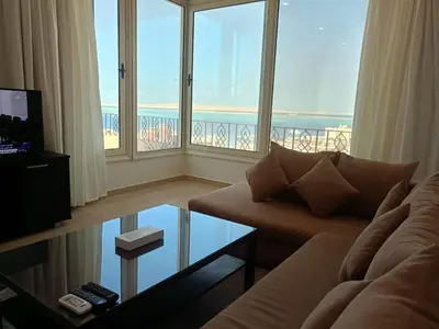 a living room with a couch and a view of the ocean at Delmar Apartments by Peaks in Hurghada