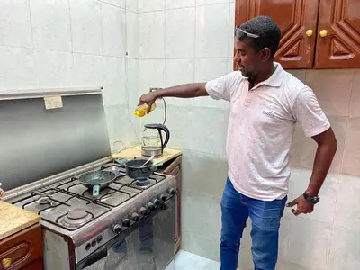a man standing in a kitchen next to a stove at La Veranda \u967d\u53f0 in Aswan