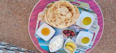 a plate of food with cheese and a pie at ATON PALACE Luxor in Luxor