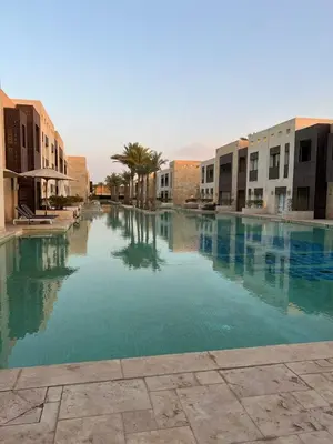 a large pool of water with buildings and palm trees at Scarab El Gouna in Hurghada