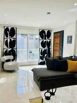 a living room with a black couch and some windows at Hurghada Stylish stay in Hurghada
