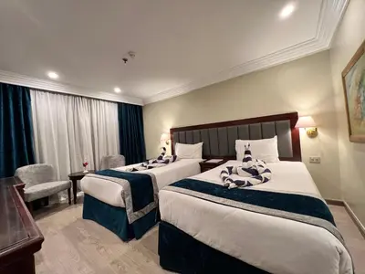 a hotel room with two beds and a desk at Hapi V in Aswan