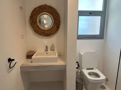 a bathroom with a sink and a toilet and a mirror at Penthouse 3 Bedrooms in Swan Lake ElGouna in Hurghada