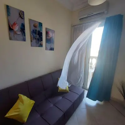 a living room with a purple couch and a window at Mamsha view 1 bedroom flat beside Russian consulate in Hurghada