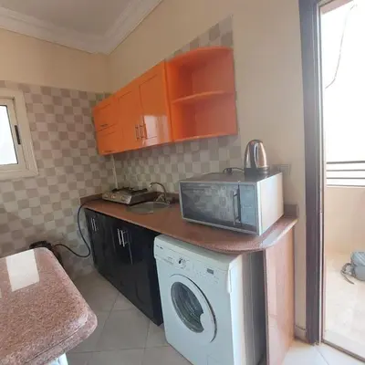 a kitchen with a microwave and a washing machine at Mamsha view 1 bedroom flat beside Russian consulate in Hurghada