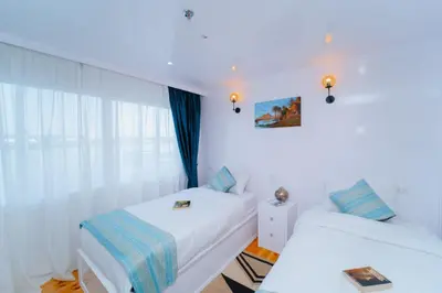 two beds in a room with white walls at Turquoise Dahabiya , 3,4,7 nights sailing between Luxor and Aswan in Luxor