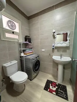 a bathroom with a toilet a sink and a washing machine at Sea View Beach Access Princess Resort Hurghada in Hurghada