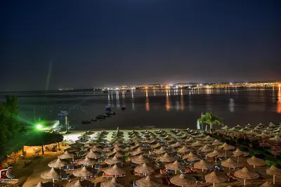 a group of umbrellas on the beach at night at Salvatore Rooms-All Inclusive Makadi in Hurghada
