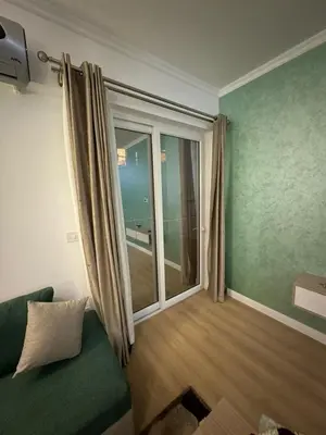 a living room with a green couch and a large window at Luxurious heart flat in Hurghada