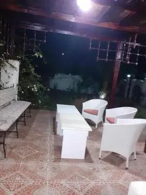 a group of white tables and chairs on a patio at Villa Sara Touristic Center in Hurghada