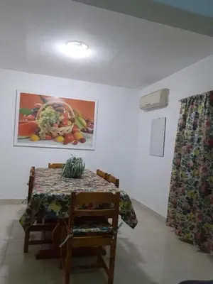 a table in a room with a painting and a chair at Villa Sara Touristic Center in Hurghada