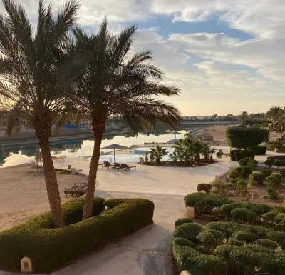 a view of a resort with palm trees and a beach at Westgolf y 62 1-8 in Hurghada
