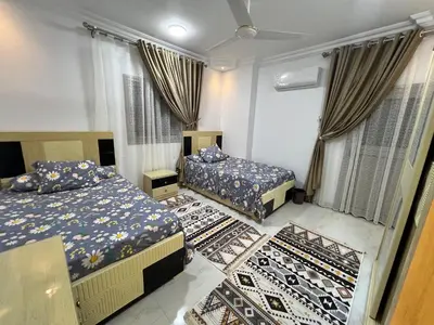 a bedroom with two beds and a rug at Excellent residential unit in Shellal