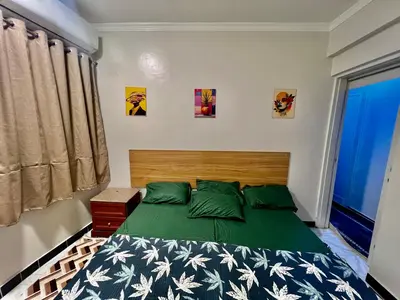 a bedroom with a bed with a green comforter at Super Elite apartment - Aswan city center apartments in Aswan