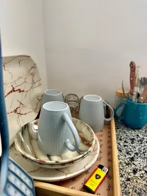 a tray with three cups and plates on a counter at Super Elite apartment - Aswan city center apartments in Aswan