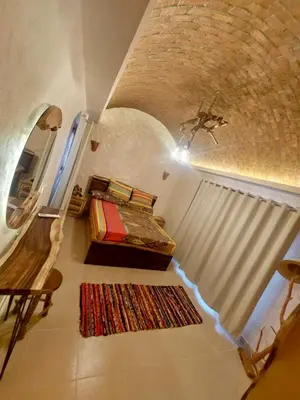a room with a staircase with a bed and a rug at Klimatyczny apartament na dachu w sercu Hurghady in Hurghada
