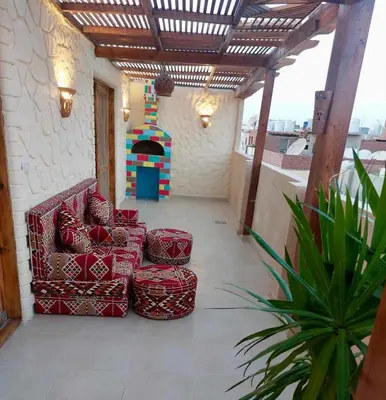 a patio with two chairs and a play house at Klimatyczny apartament na dachu w sercu Hurghady in Hurghada