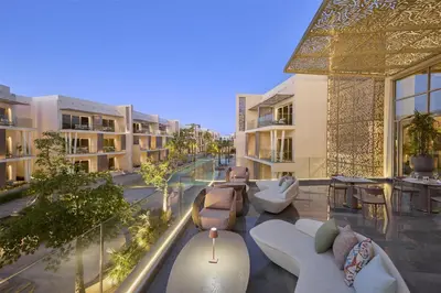 an apartment patio with couches and tables and chairs at Doubletree By Hilton Mangroovy El Gouna Resort in Hurghada
