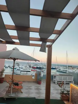 a patio with an umbrella and chairs and a marina at comfort marine 2 in Hurghada