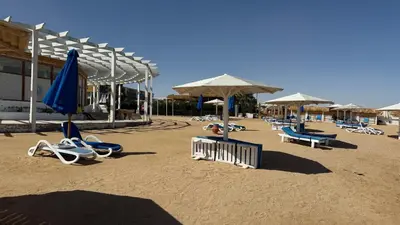 a beach with chairs and umbrellas on the sand at Comfy Studio, Pools, private Beach at peaceful Resort in Hurghada