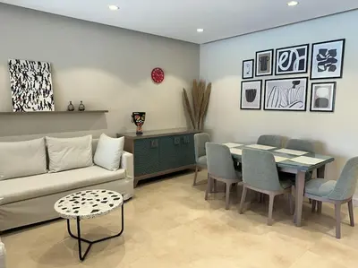 a living room with a couch and a table and chairs at Marvelous 2BR - Free Beach Access and Pool Access In Mangroovy in Hurghada