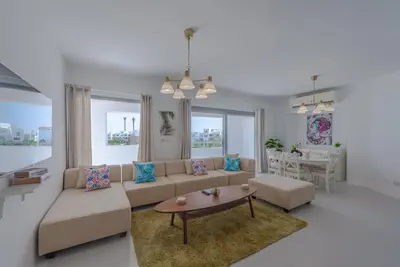 a living room with a couch and a table at Elegant 3BR on Swan Lake Crystal Lagoon at Elgouna Families Only in Hurghada