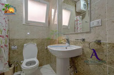 a bathroom with a sink and a toilet and a mirror at The Awesome 3-Bedroom Apartment & 2 bathroom in Al-Ahyaa Hurghada in Hurghada