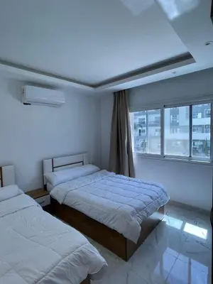 a bedroom with two beds and a window at Fanadir Bay in Hurghada