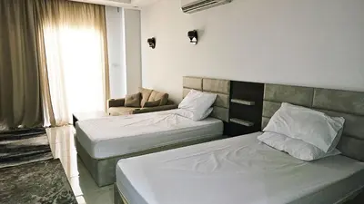 a room with two beds and a couch in it at شاليه ب Selena Bay Resort in Hurghada
