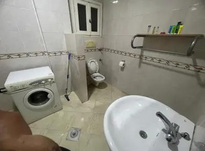 a bathroom with a sink and a washing machine at Happy home in Hurghada