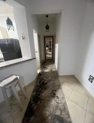 a room with a damaged floor with a chair and a hallway at Happy home in Hurghada