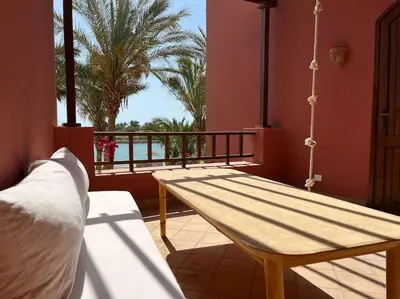a porch with a hammock and a swing at Cozy Townhouse in West Golf - El Gouna in Hurghada