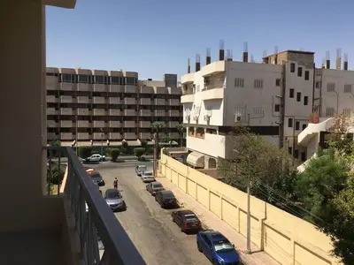 a view of a city with cars parked on a street at Abbady tower in Jazīrat al ‘Awwāmīyah