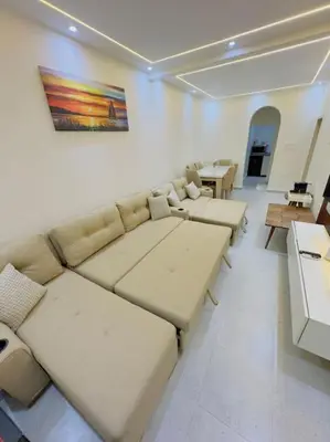 a living room with couches and tables and a painting on the wall at Moly House in Aswan