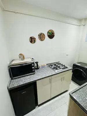a kitchen with a microwave and a stove top oven at Moly House in Aswan