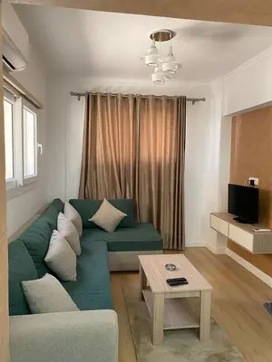a living room with a green couch and a table at CC Luxurious Apartment in Hurghada